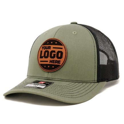 Loden/black Richardson 112 trucker hat with a round tan leather patch that reads “Your Logo Here” and a black mesh back.